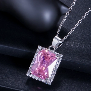 Makroaufnahme einer silbernen Halskette mit einem rechteckigen rosa Zirkon-Anhänger