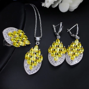 Close-up of bridal jewelry set with yellow marquise stones on black background