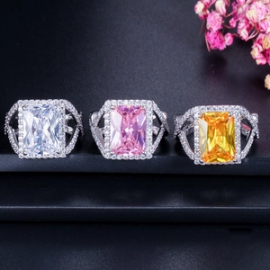 Makroansicht von drei luxuriösen Zirkonia-Ringen in Weiß, Rosa und Gelb mit Diamanten