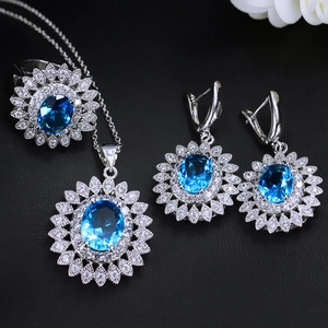 Detailed view of sunburst jewelry set with blue oval gemstones on black leather