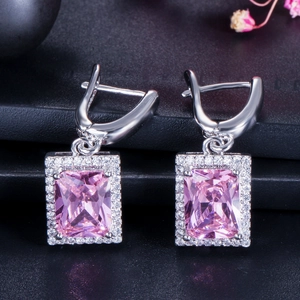 Makroaufnahme von Silber-Ohrhängern mit rosa Zirkon im Smaragdschliff und weißen Steinen