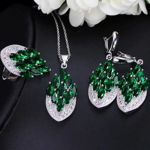 Detail of bridal jewelry set with marquise emerald stones and silver zircon settings
