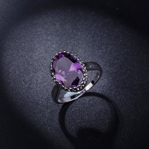 Makro-Detail eines lila Zirkon-Rings mit Vintage-Perlenrand in schwarzer Fassung