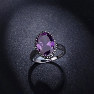 Vintage Ring mit ovalem lila Zirkon und Silberbeschichtung auf dunklem Hintergrund