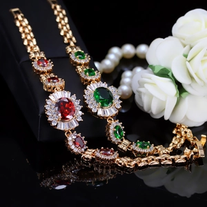 Elegante vergoldete Kupferarmbänder mit roten und grünen Zirkon-Edelsteinen im Schmuckkästchen