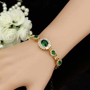 Detailansicht eines smaragdgrünen Zirkonia-Goldarmbands im königlichen Vintage-Stil am Handgelenk
