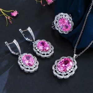 Macro view of bridal jewelry set featuring pink oval cubic zirconia and silver pavé accents
