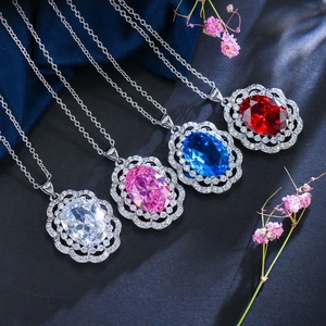 Close-up of four colored oval gemstone necklaces with sparkling halo diamond settings