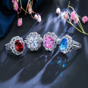 Detail view of multicolored oval 3A zircon rings with floral halo in silver finish