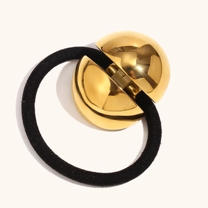 Minimalist 18K gold plated spherical hair tie with polished mirror finish on cream background