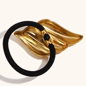 Élastique cheveux minimaliste avec pendentif aile plaqué or 18K sur fond blanc