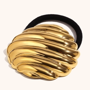 Macro shot of 18K gold plated shell textured metal plate on black elastic hair tie