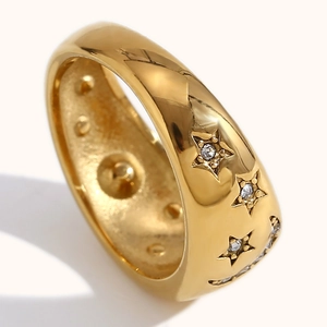 Close-up of gold plated ring featuring star engravings with inset white zircons