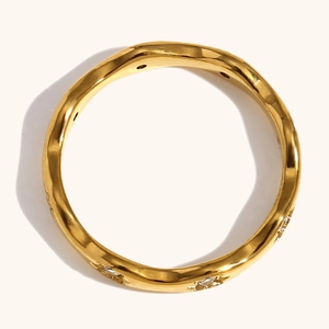 Macro detail of wave shaped 18K gold plated ring with star shaped stone settings