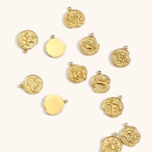 Vista macro detallada de los colgantes del zodiaco bañados en oro 18K con relieves