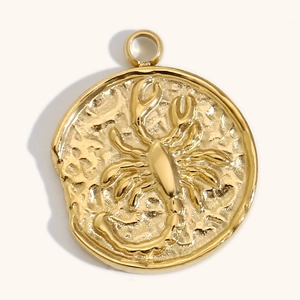 Detalle del colgante del zodiaco bañado en oro de 18K con relieve de escorpión y textura martillada