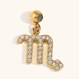 18K gold plated Scorpio zodiac pendant with sparkling cubic zirconia on beige background