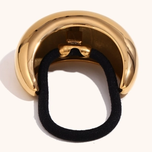 Detail of 18K gold-plated crescent moon metal cuff with black thick elastic hair tie