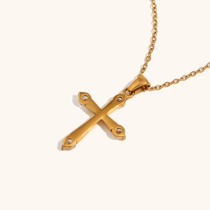 Detail showing an 18K gold plated cross pendant necklace with zircon stones in a macro view