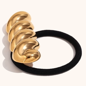 Detailed view of twist metal hair tie with 18K gold plated spiral charm and black cord