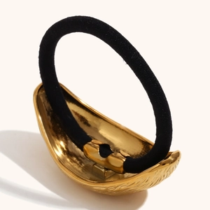 Detailed view of 18K gold plated metal buckle with olive leaf texture on black hair tie