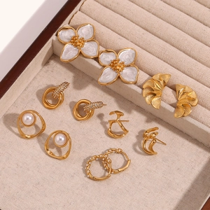Minimalist 18K gold plated earring collection with pearls and crystals on beige tray