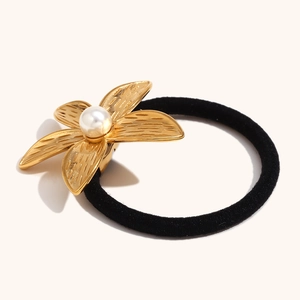 Détail d'un élastique à cheveux fleur de frangipanier doré 18K avec perle d'imitation