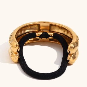 Detail of 18K gold-plated double-layer hair tie with irregular hammered lava texture