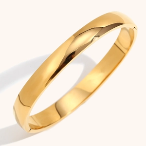 Polished 18K gold plated wide bangle featuring a side hinge and glossy metallic finish