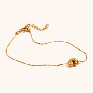 Detail of 18K gold-plated bracelet featuring a polished U-shaped bead and lobster clasp