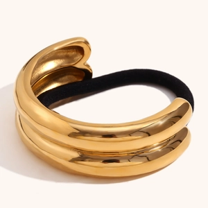 Close-up of polished 18K gold-plated double-layer metal fastener on black hair elastic