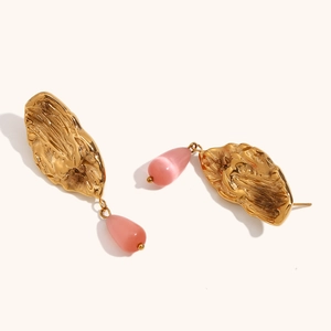 Macro detail of 18K gold plated butterfly wing earrings with pink gemstone drop