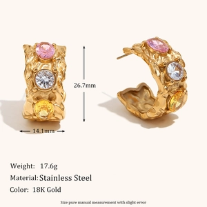 Macro view of 18K gold plated C-shaped earrings with lava texture and colored crystals