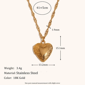 Close-up of 18K gold stainless steel heart locket with intricate floral engravings