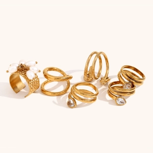 Macro detail of 18K gold-plated rings with hammer texture, pearls and zircon charms
