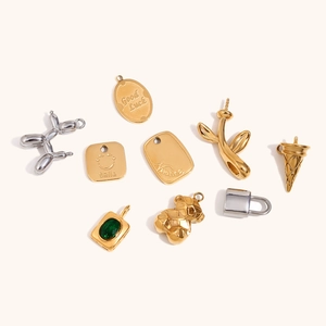 Macro shot of 18K gold plated stainless steel charms including robot bear and oval tags