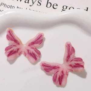 Detail of pink and purple glitter resin butterfly charms for DIY craft jewelry making