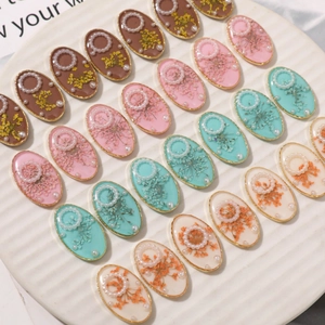 Oval resin dried flower charms with pearls and gold frames in four various colors