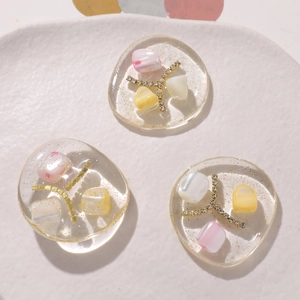 Macro shot of three resin butterfly hair clip charms with glitter and gold cross details