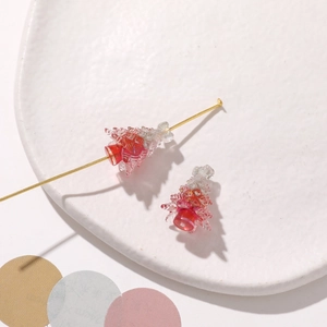 Detail of gradient red Christmas tree resin bead on a pin for DIY jewelry making