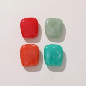 Close-up of vibrant square resin beads in red and marble green for DIY earring crafts