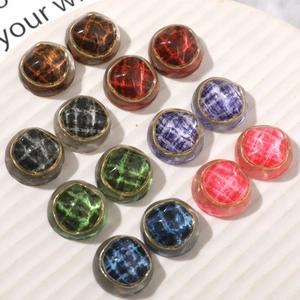 Irregular textured resin buttons with fabric pattern and gold trim on white display tray