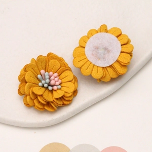 Macro detail of 3cm yellow artificial daisy fabric flower showing layered petals and backing
