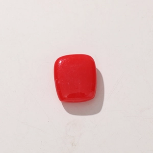 Detail shot of a red cubic resin bead with a polished finish and semi-translucent texture