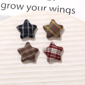 Macro detail of plaid fabric star patches in four colors for DIY craft accessories