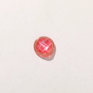 Detail of round red checkered resin charm with gold rim for DIY jewelry making