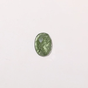Détail d'un cabochon ovale en résine avec texture verte métallique et effet pailleté