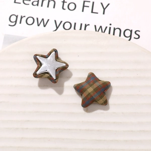 Detailed close-up of retro plaid fabric star-shaped DIY accessory parts on ceramic dish