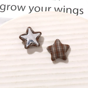 Detail of vintage plaid star-shaped fabric patches and metal star DIY jewelry accessories