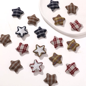 Macro shot of plaid fabric star patches with silver center dots for DIY jewelry